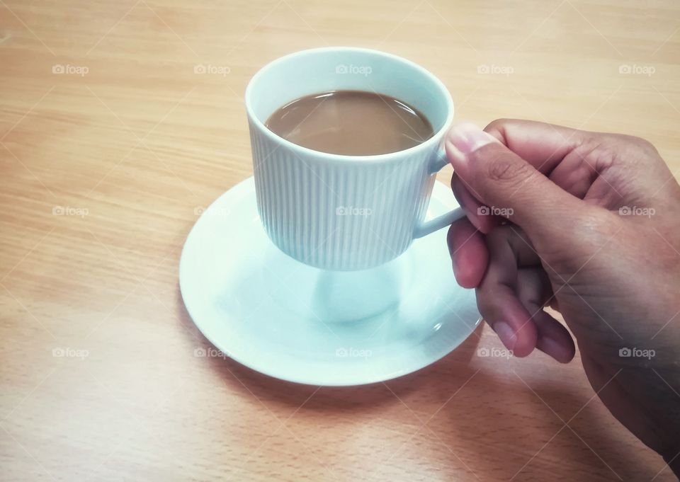 Hand hold a cup of coffee.
