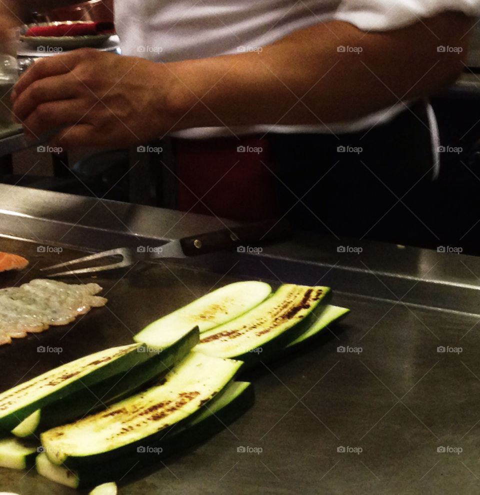 Zucchini cooking on a grill in a Japanese Benihana style teppanyaki