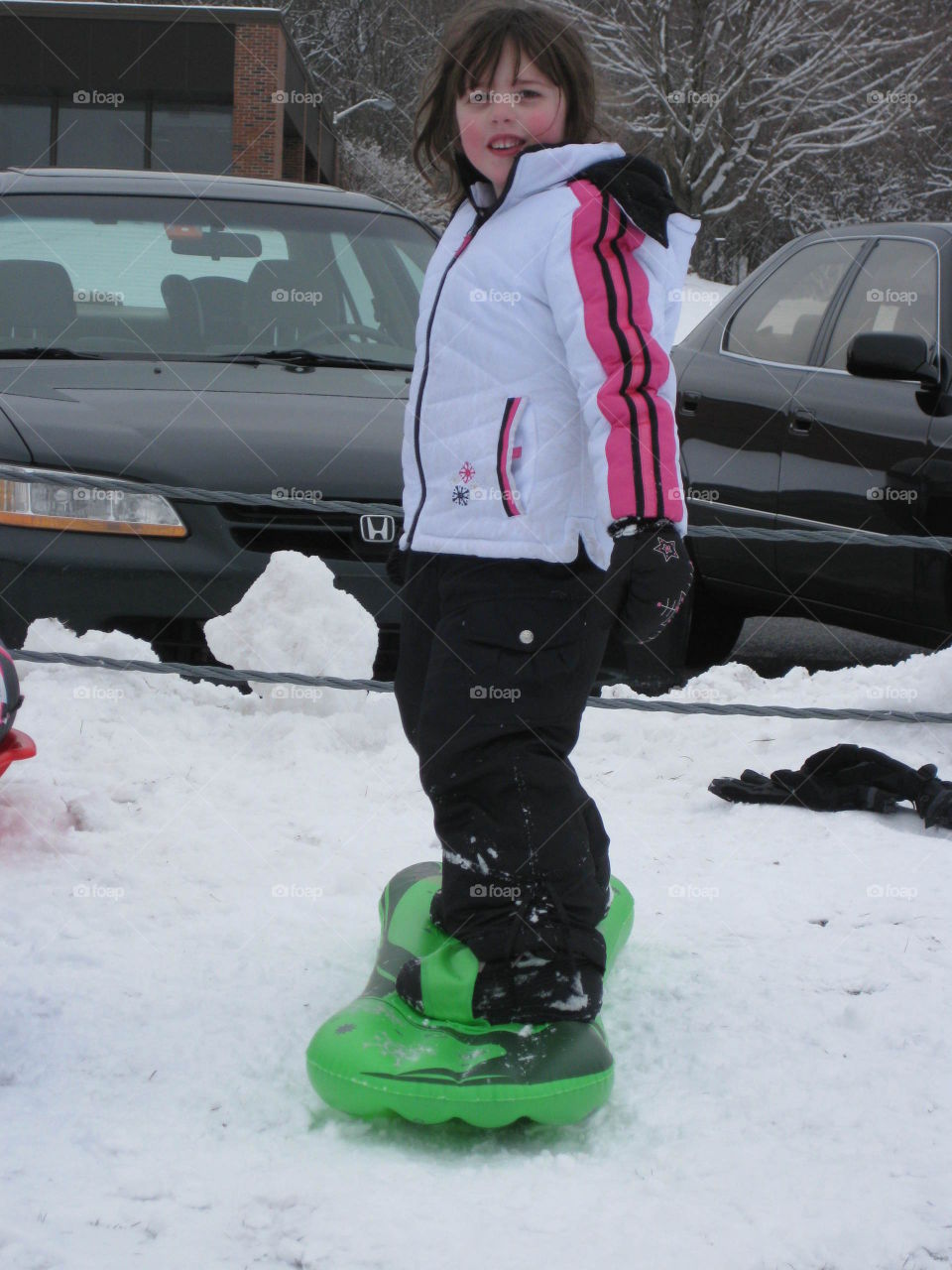 Girl standing on inflatable sledge