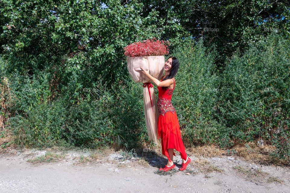 Woman Dances with a Large Bouquet of Red Flowers