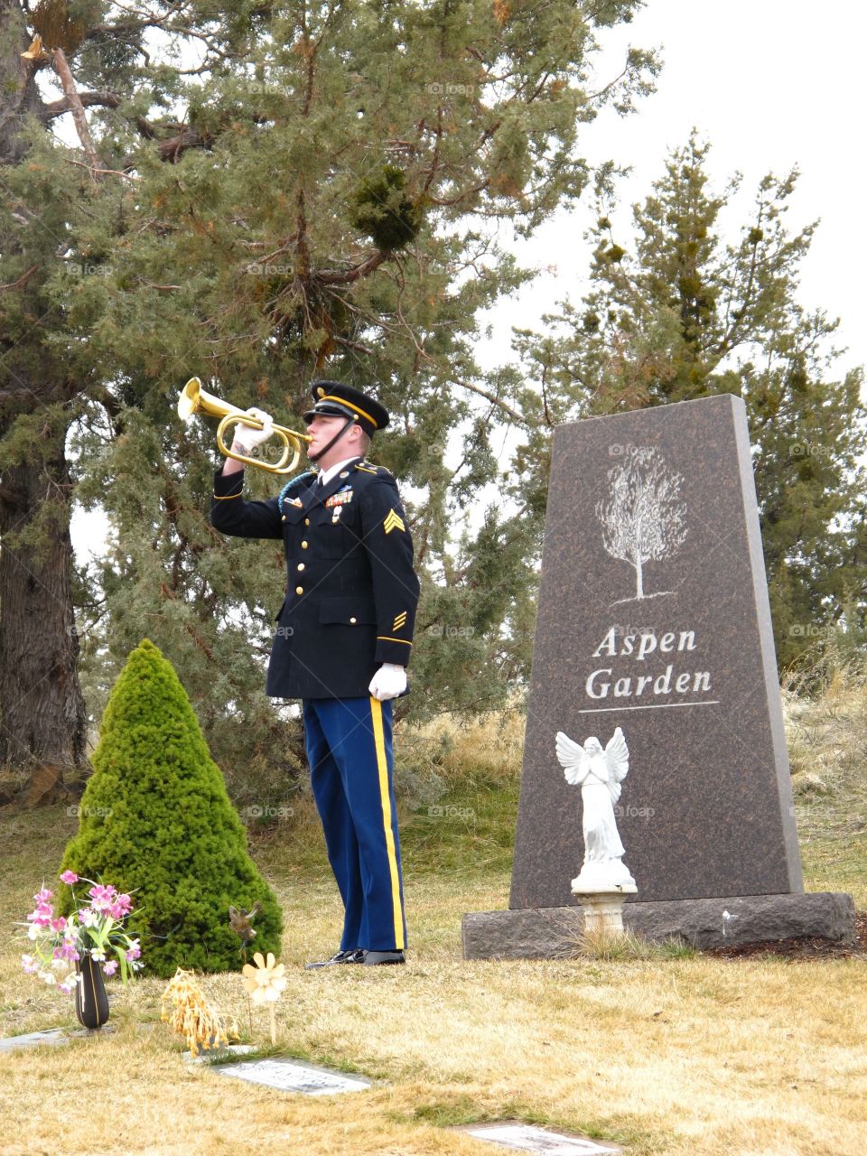 An Army sergeant in ceremonial uniform plays Taps at the funeral of a great World War II veteran on a cold winter day in Central Oregon. 