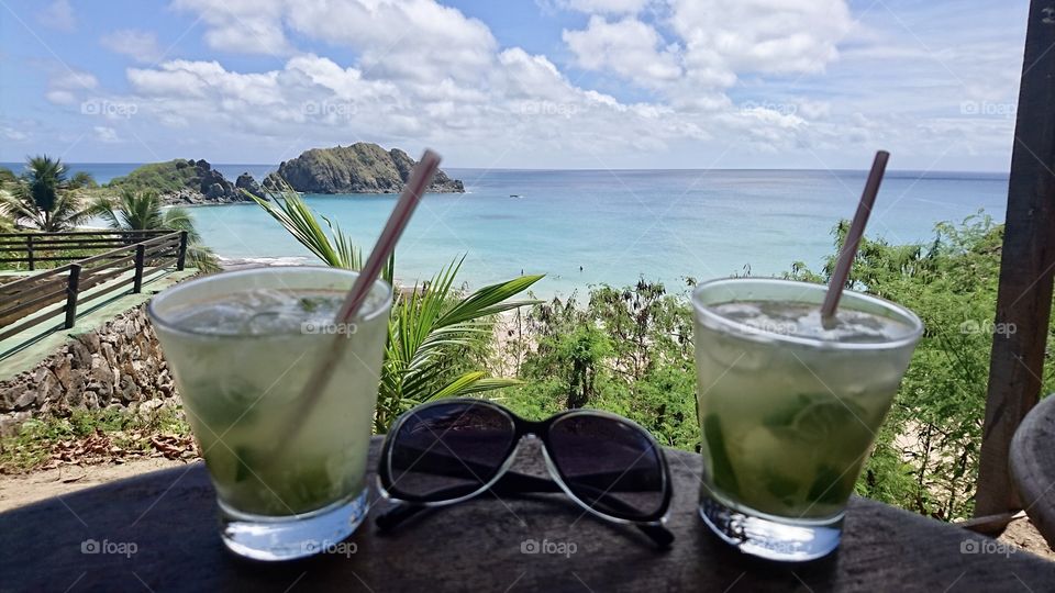 Two Caipirinha against Fernando de Noronha beach 