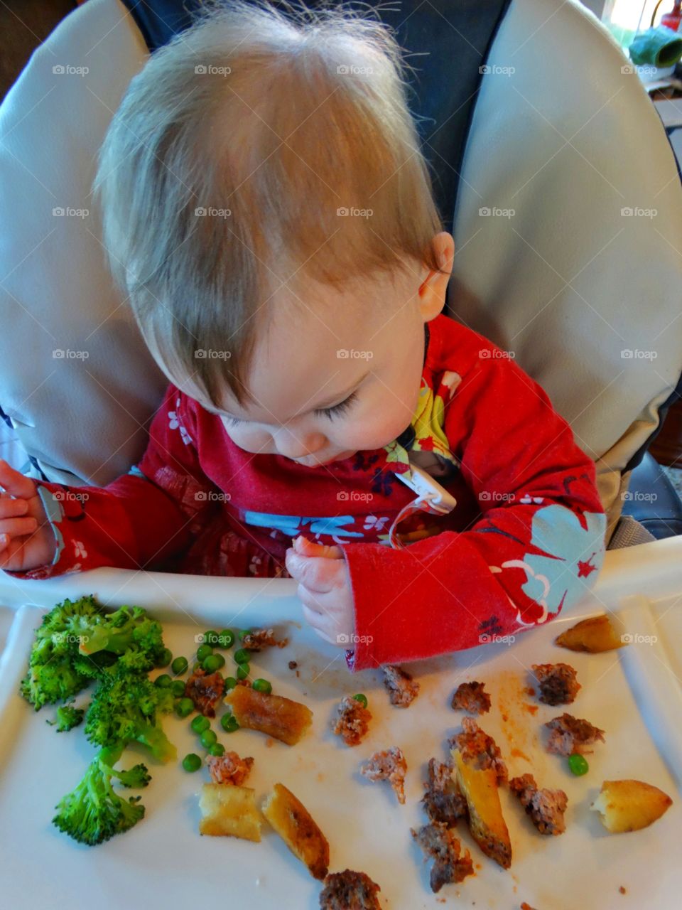 Baby Eating In A Highchair