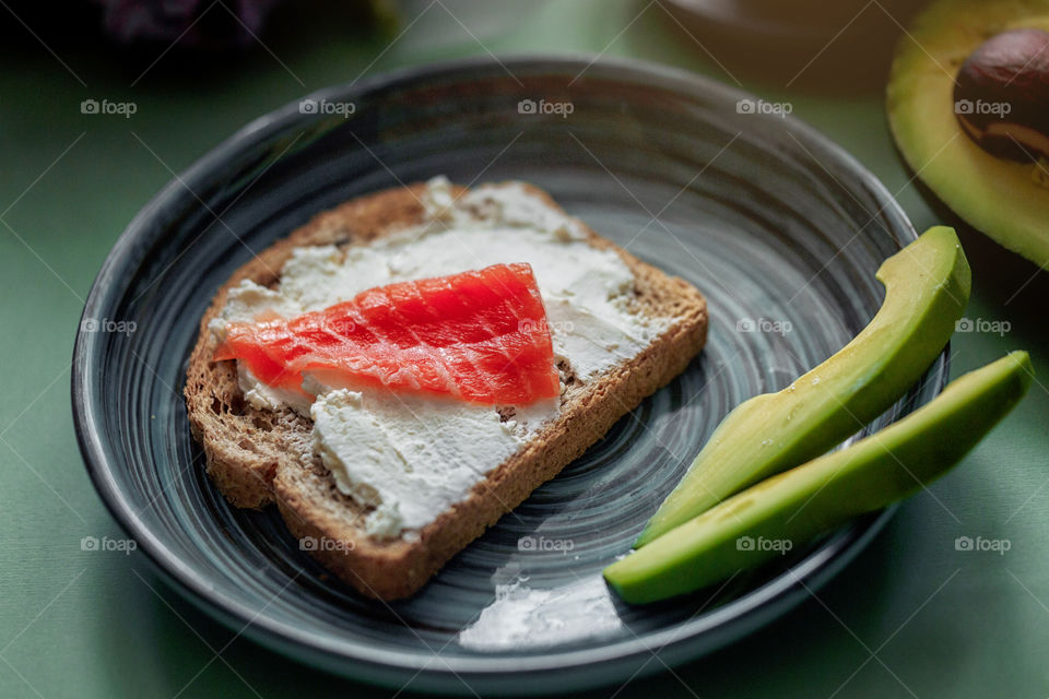 Breakfast with toast with cream cheese, red fish and avocado 