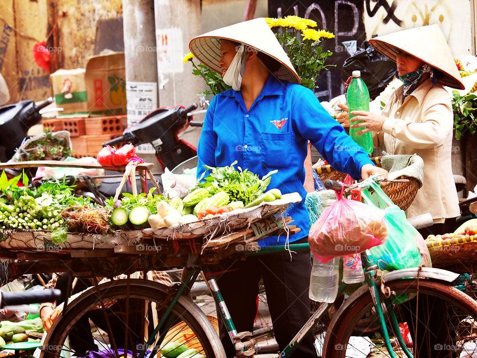 Vietnamese woman selling vegetables on the bicycle