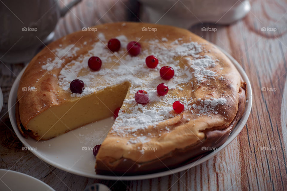 Cheesecake with cranberries and sugar on wooden background 