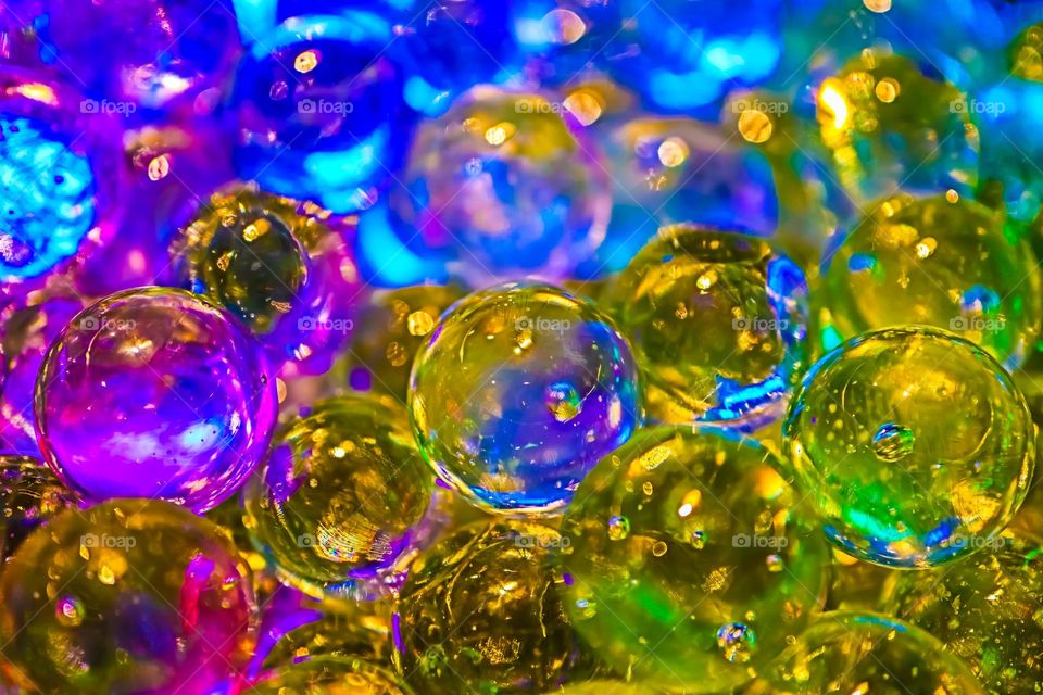 Colorful shiny glass marbles reflecting a rainbow of colors, closeup macro image 