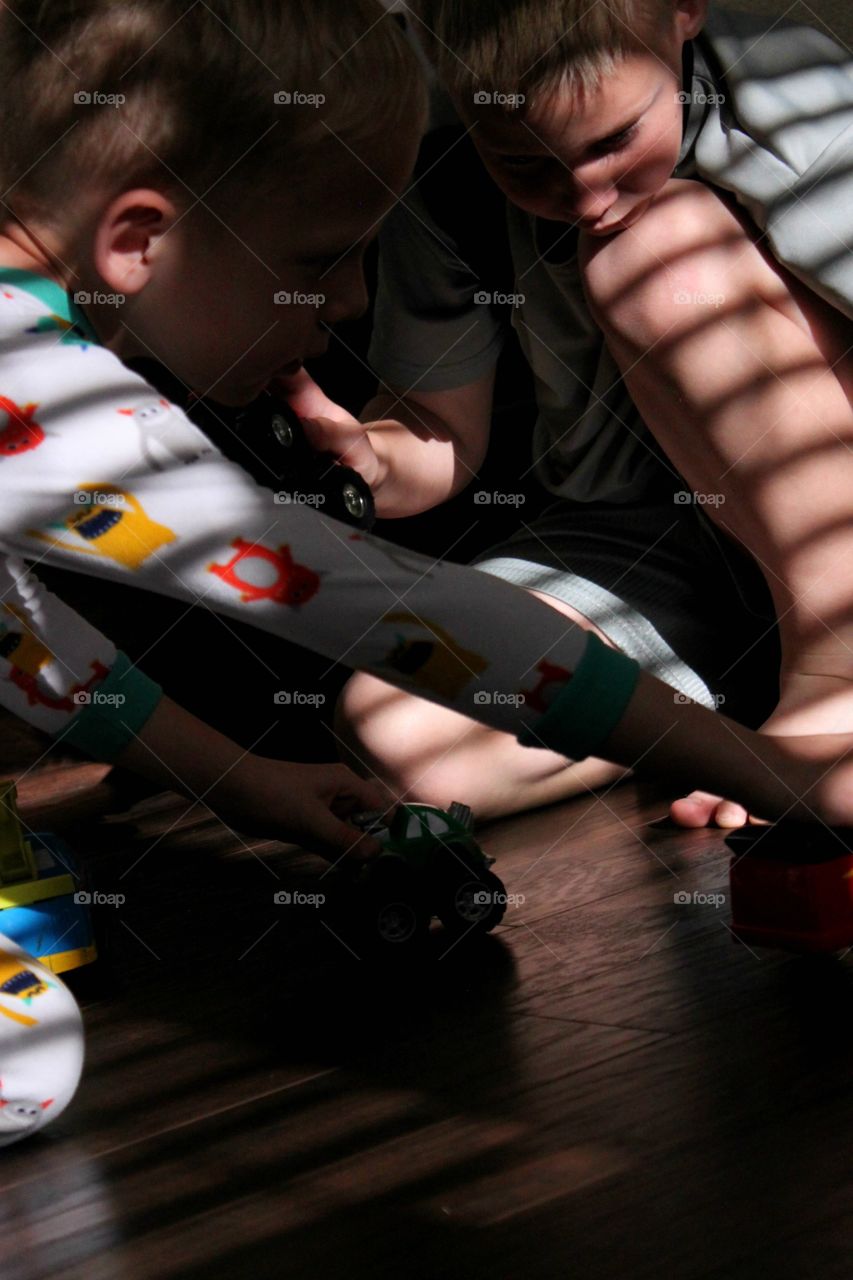 Brothers playing with toy vehicle