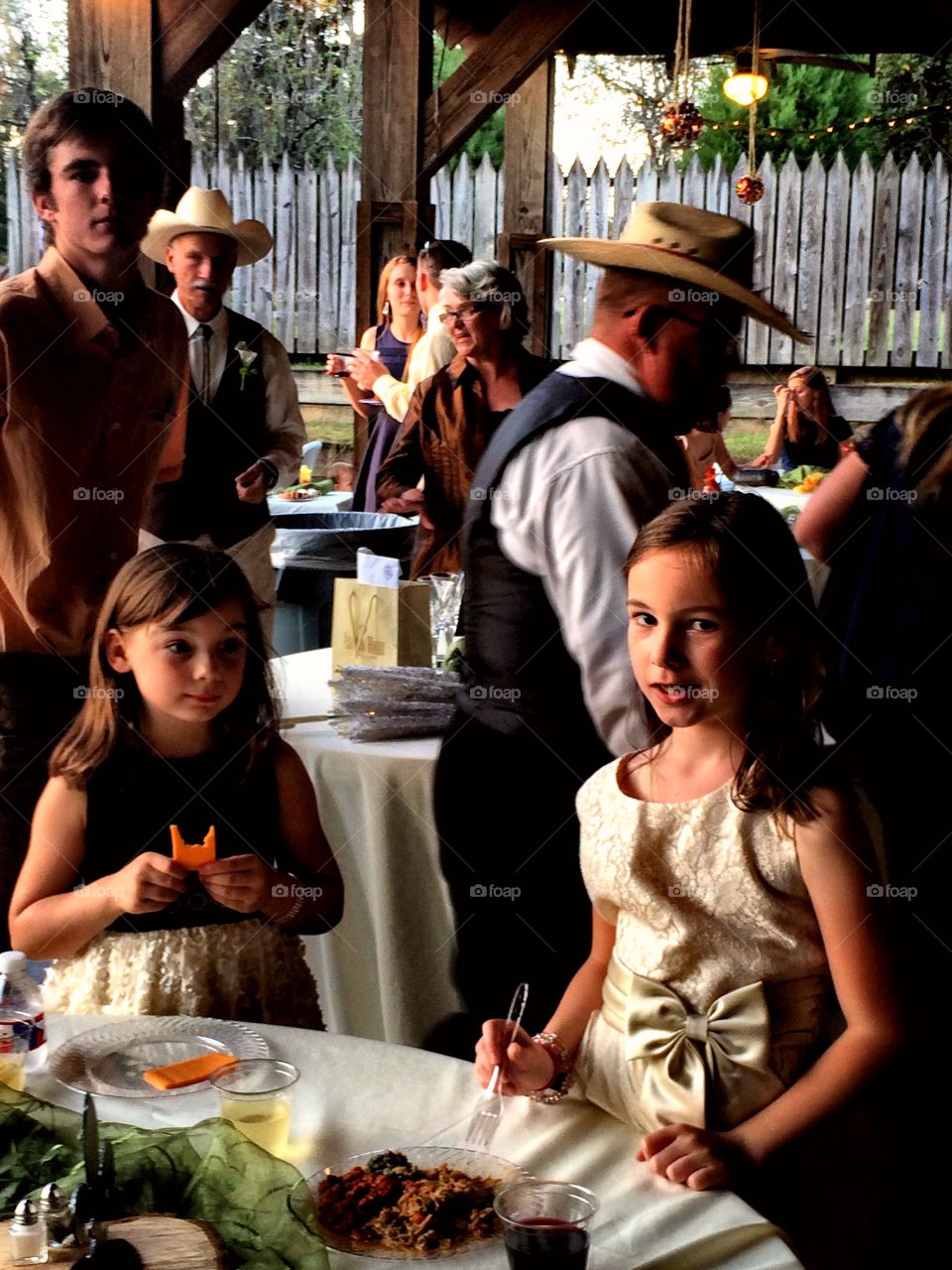 A candid portrait of two flower girls at a western-themed wedding.