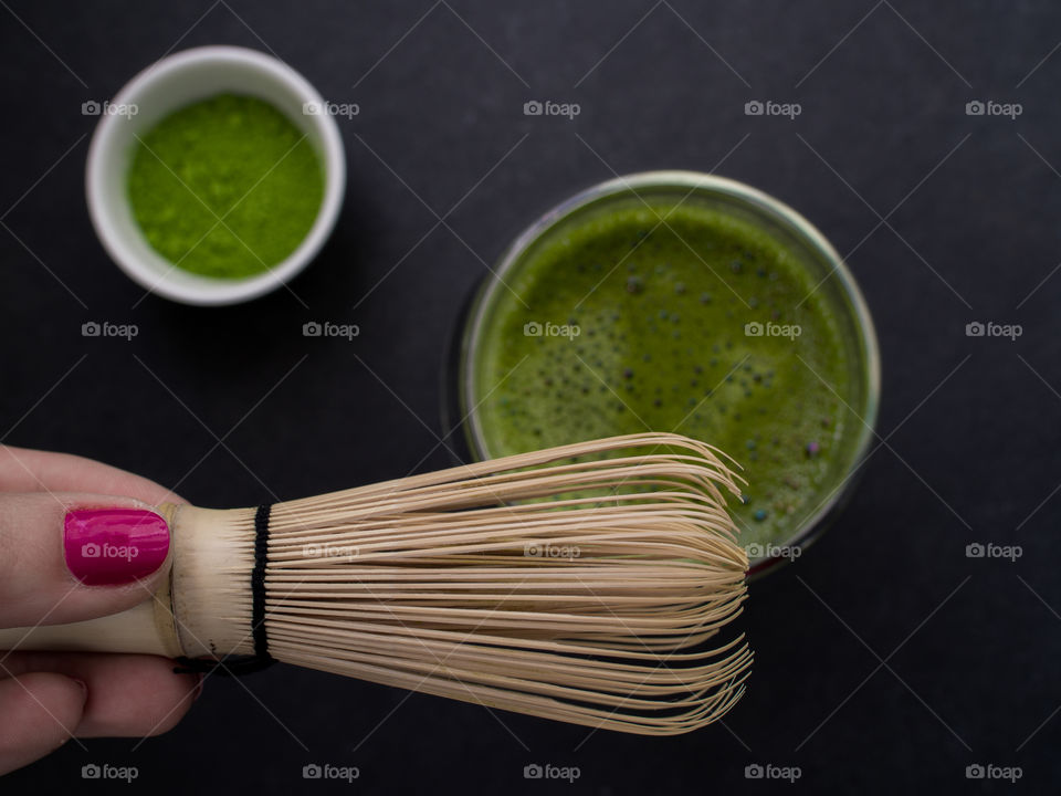 Hand holding tea whisk