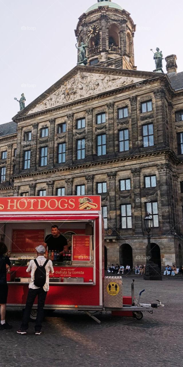 An unusual view of a modern food stall against the backdrop of an old palace