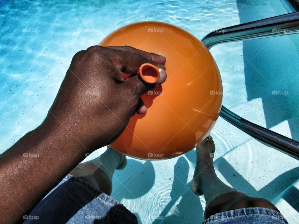blowing up a balloon at the pool