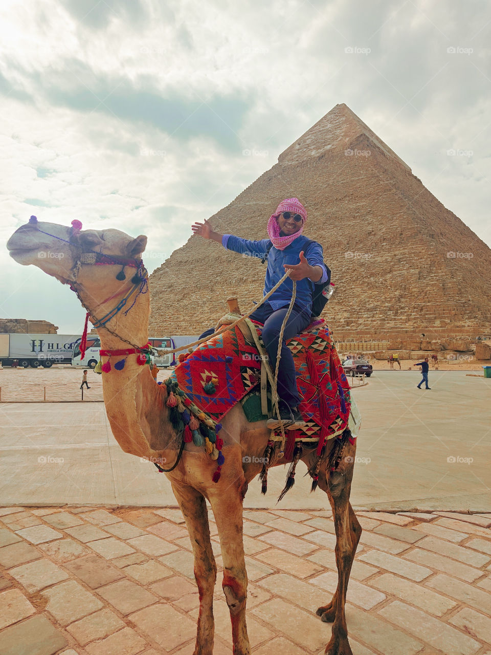 Egyptian youth riding a Camel 🐪 front of great Pyramids at cloudy day