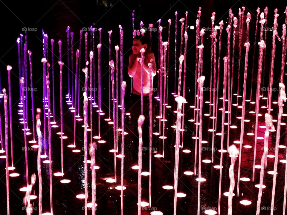 Child Playing In A Water Fountain