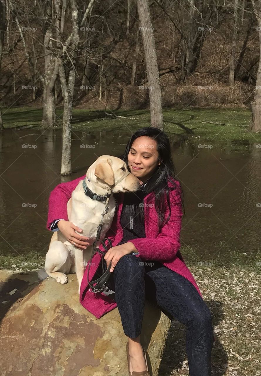 Girl resting on a rock with her dog