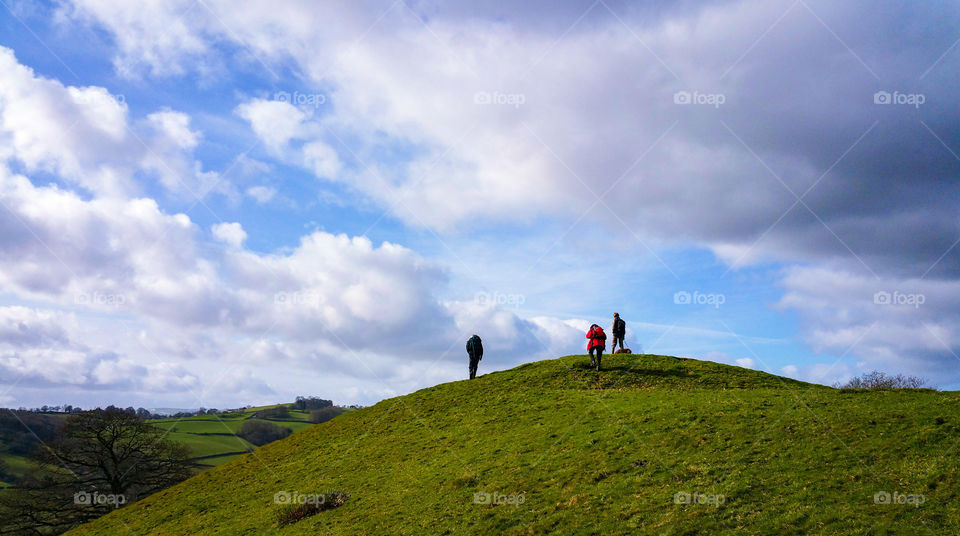 People hiking on green mountain