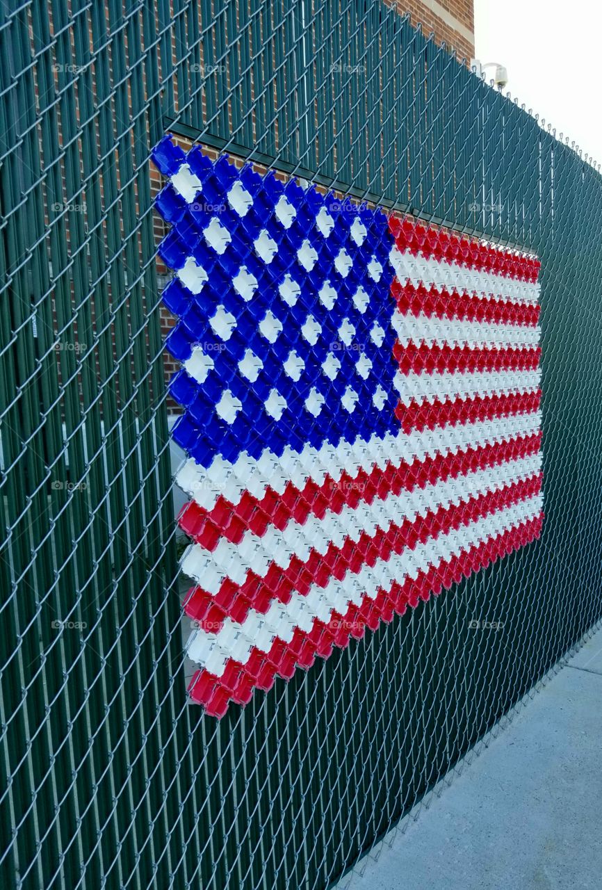 US flag made of what I believe is recycled plastic, worked into a fence.