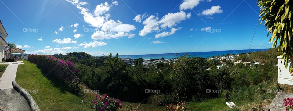 A panoramic hilltop view of the city of Rincon, Puerto Rico with the beautiful turquoise ocean all along the horizon