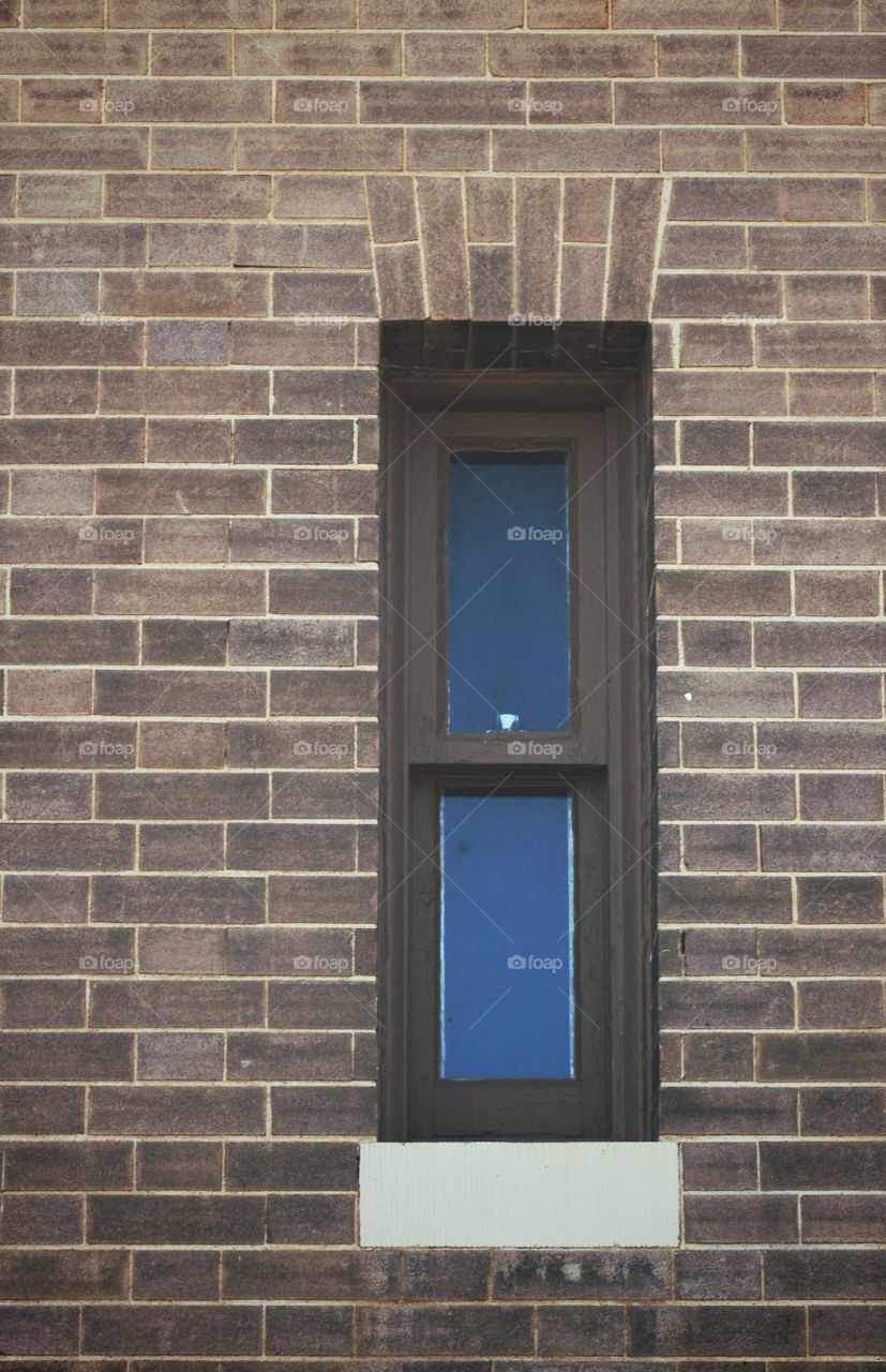 Shapes: Rectangle - A narrow window with painted trim in an vintage  brick building 