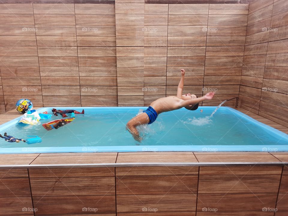child jumping in the pool cooling off