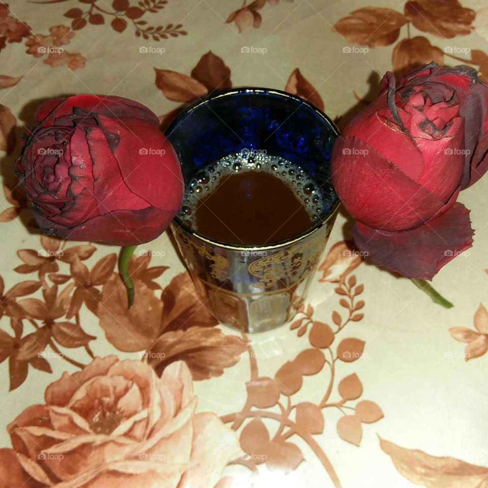 Beautiful cup of tea between two roses