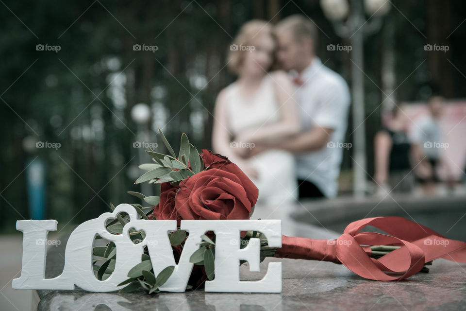 Love text on table with rose flowers