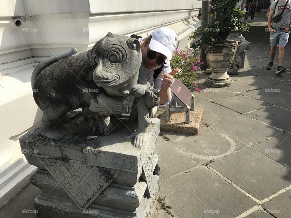 a statue of a monkey in front of a temple in bangkok