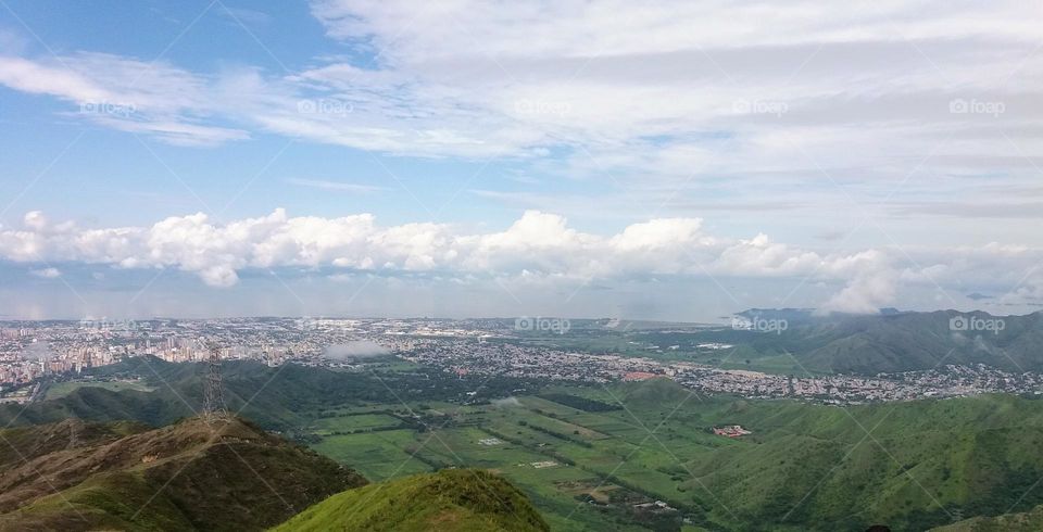 Landscape of Maracay garden city in which you can see the beautiful city covered in clouds as if they were waves that join at the end with Lake Velencia