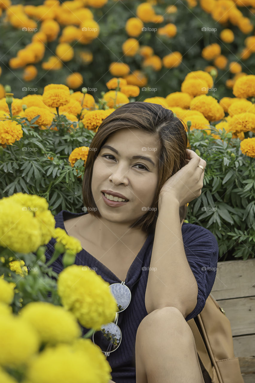 Woman in Yellow Marigold flowers garden or Tagetes erecta in garden