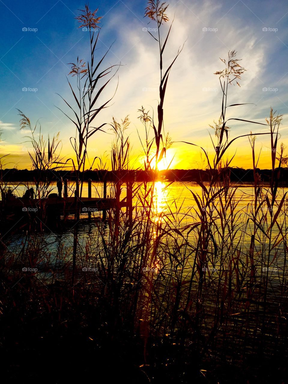 Pier in lake during sunset