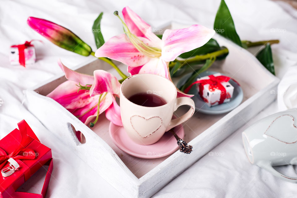 Tea on the tray with flower and gift