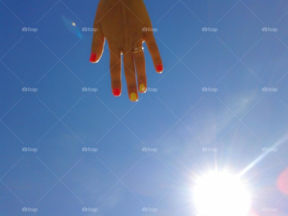 Hi summer. Sun, hand and sky. Yellow manicure