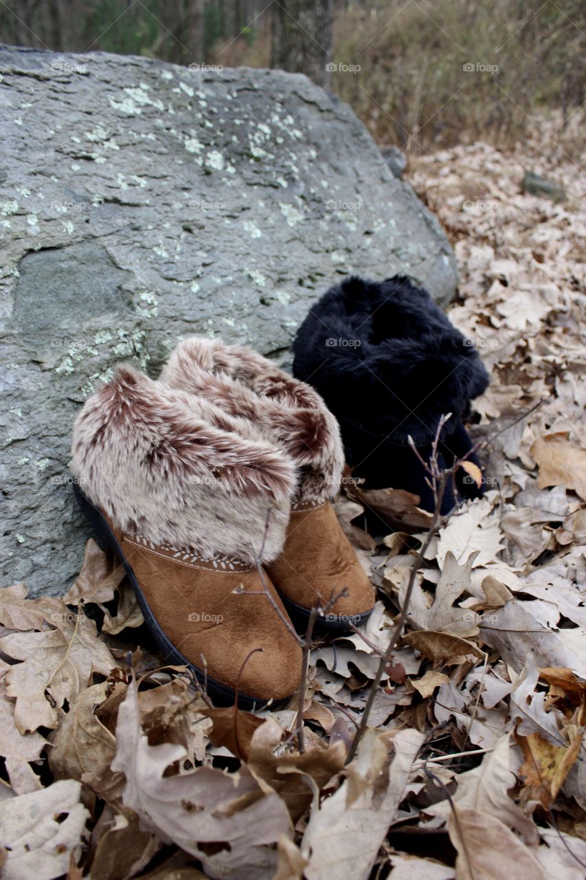 Buckskin and Black slippers leaning on rock