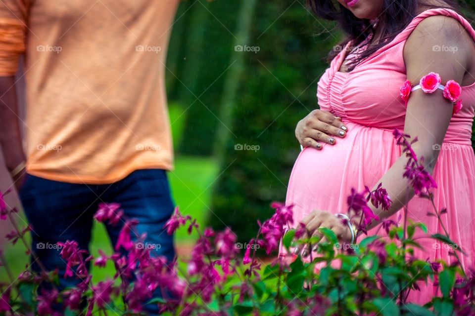 Indian couple celebrating pregnancy outside. Colorful image. 