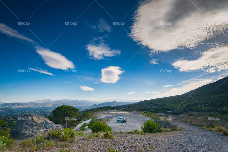 Tiny speck in environment. 4x4 terrain car on mountain plateau. Andalusia. Andalucia. Spain. Europe.