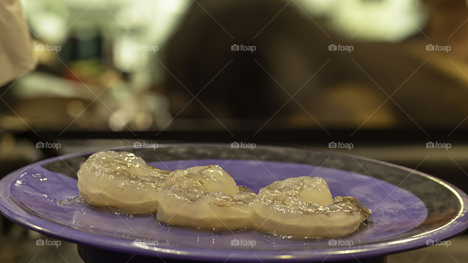 Banana shrimp  peeled on a plastic plate green.