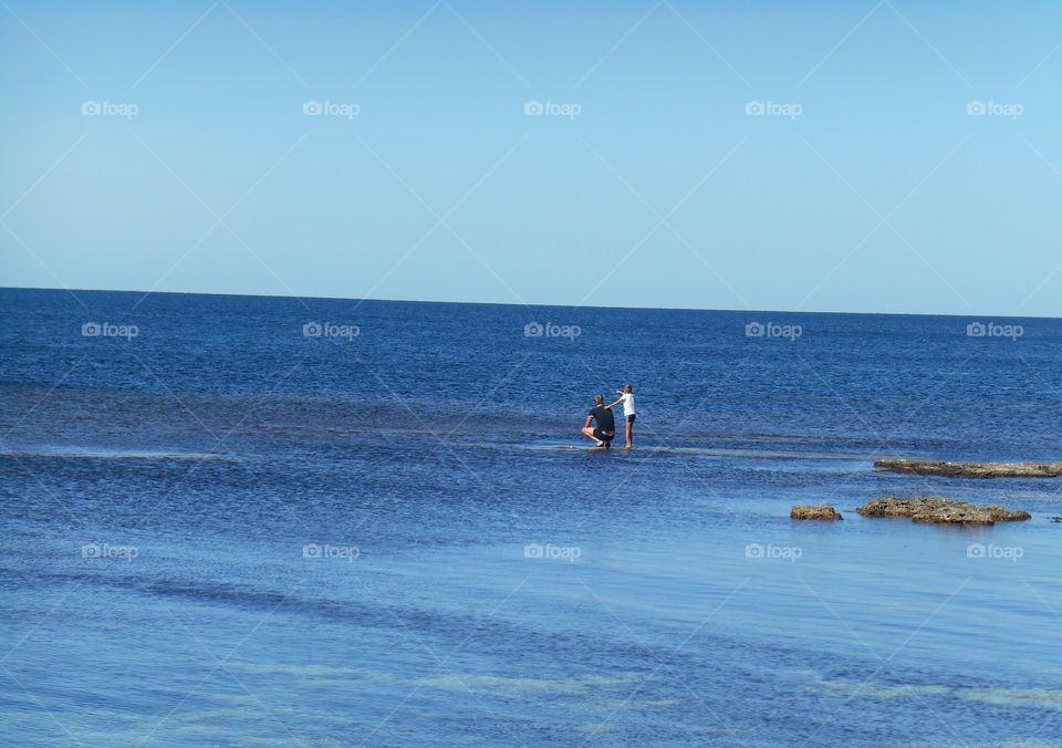 family resting on a sea summer blue sky background