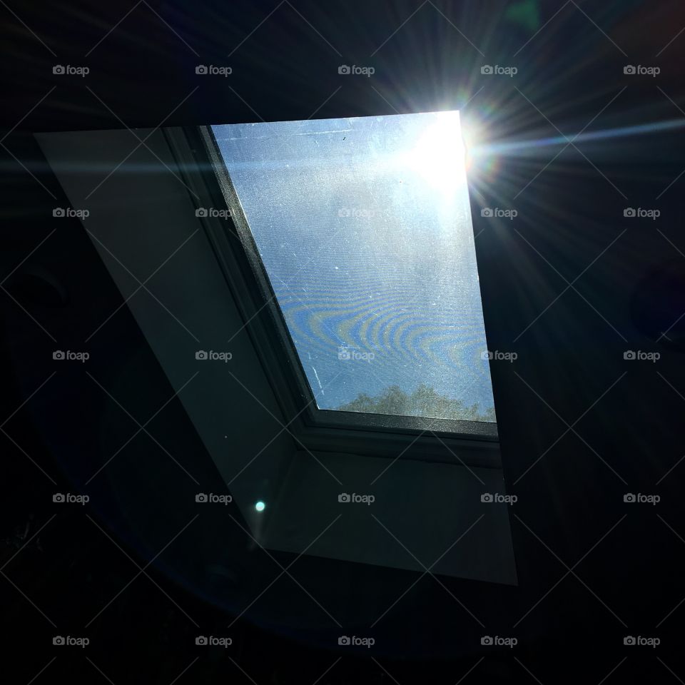 Skylight with blue sky & sun shining through.