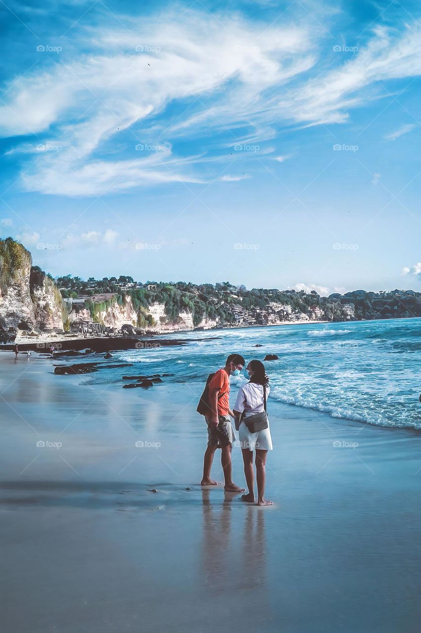 Denpasar, Bali, Indonesia - August 30, 2023: Two people are vacationing on a beach located in Bali, Indonesia