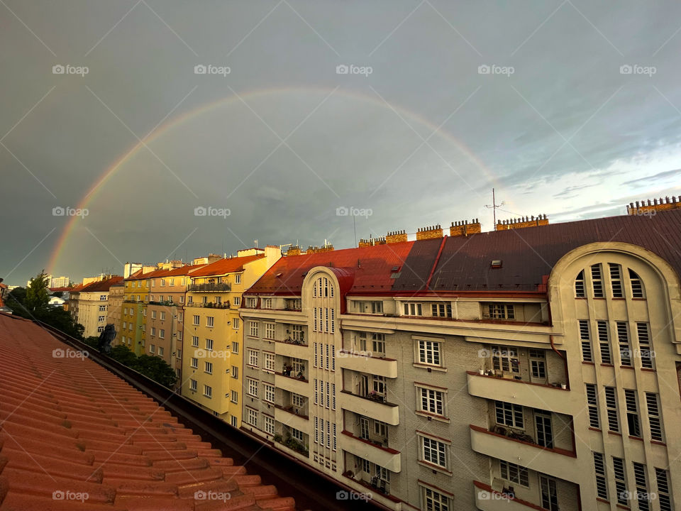 Rainbow over the houses photographed from the window.