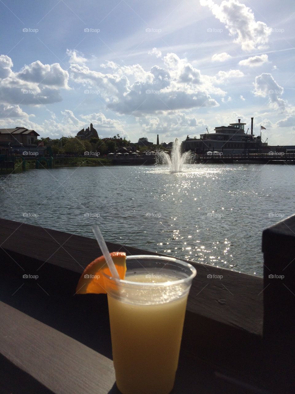 Refreshing fruity drink overlooking a lake and fountain