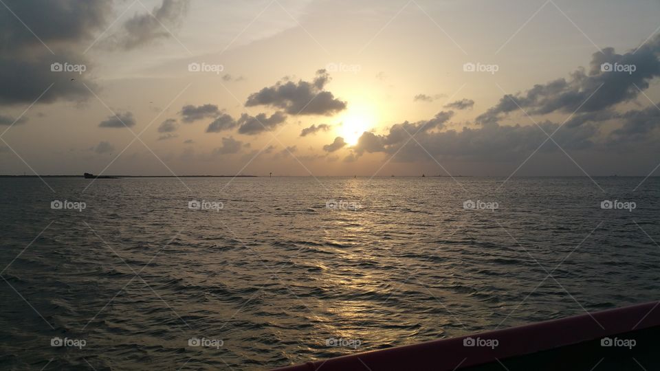 I took an evening ferry ride down in the Gulf of Mexico and caught this beautiful picture of the sun setting behind the clouds. It definitely was a picture perfect moment.