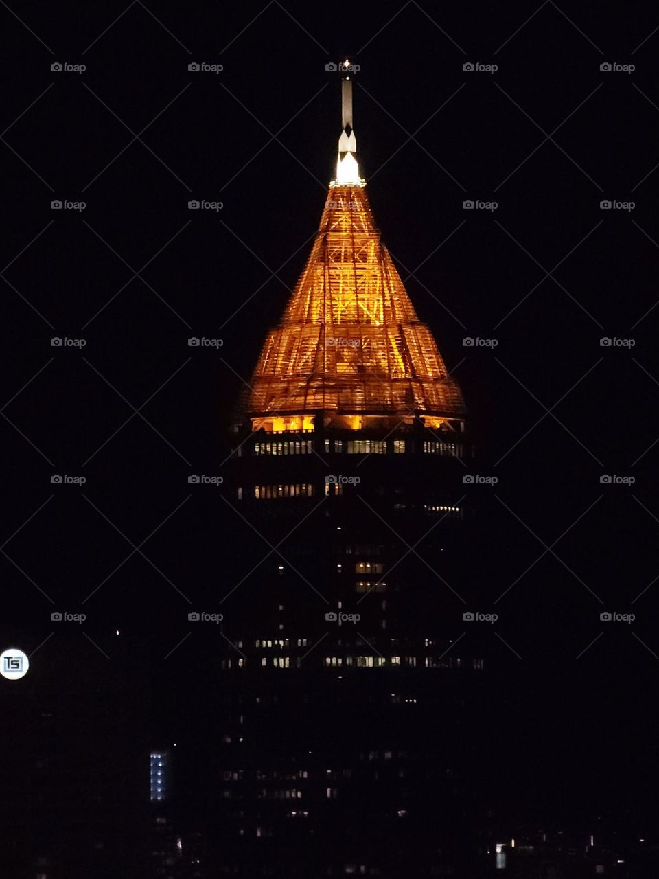 The top of a downtown building casts a warm glow as an architectural highlight in a major city