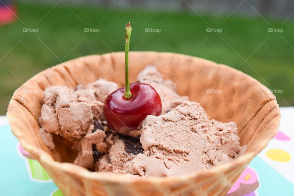 Ice cream scoops in cone with berry