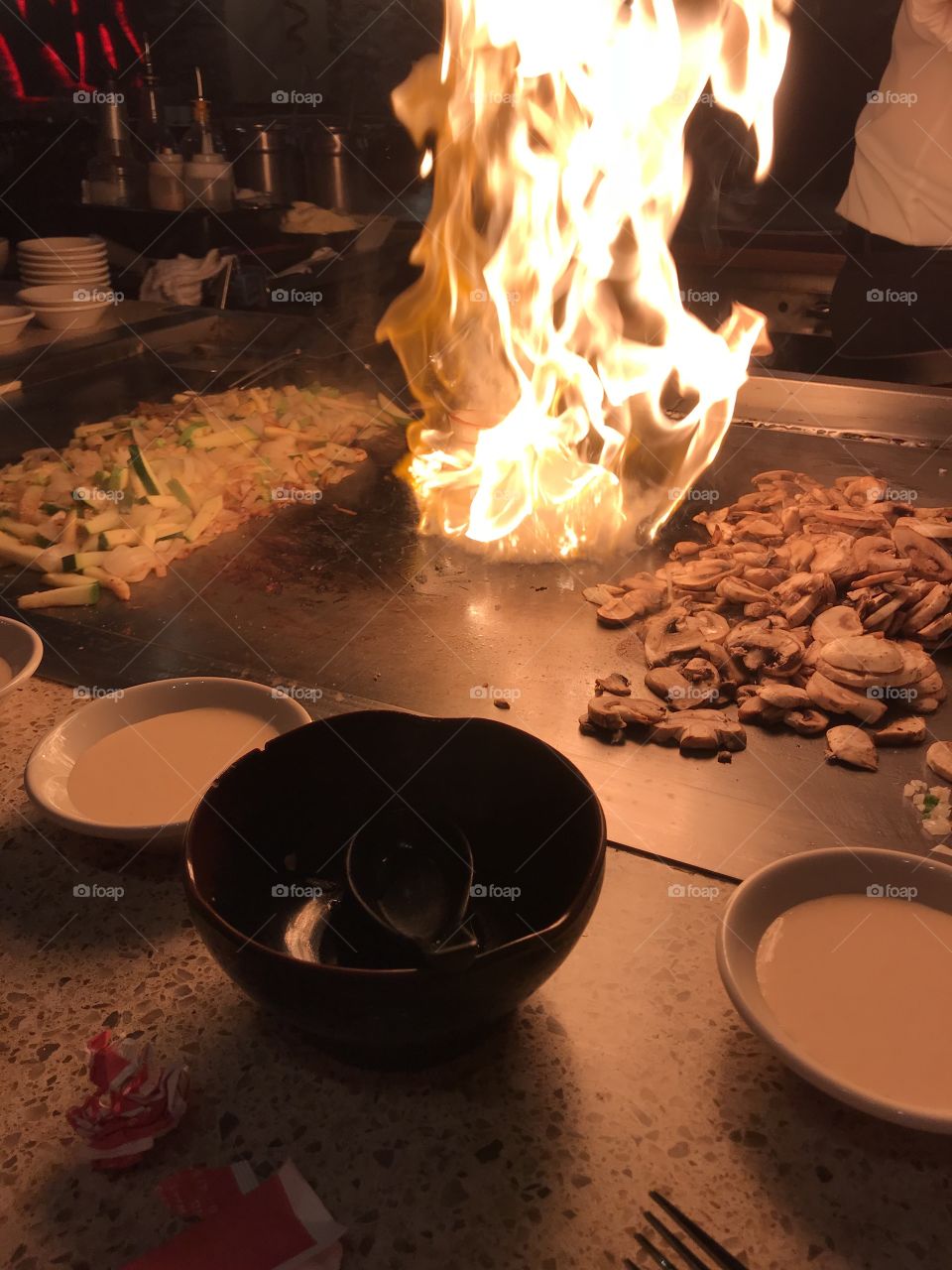 Hibachi fire between mushrooms and veggies of onions and zucchini 