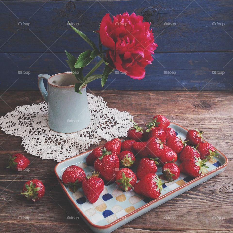 strawberry and peony on wooden table