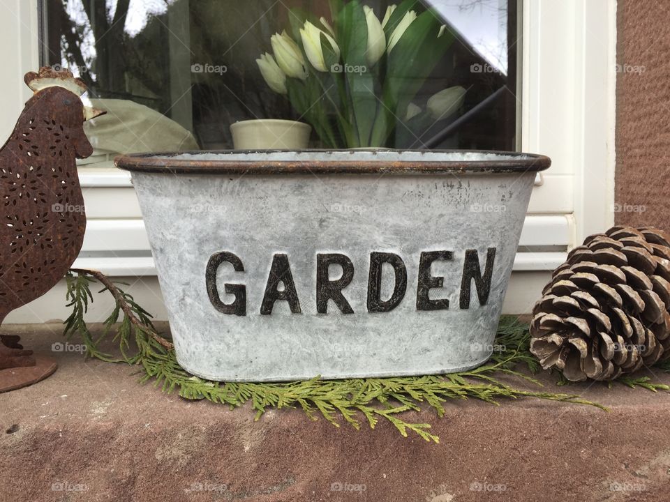 Cachepot with text "Garden" on a windowsill
