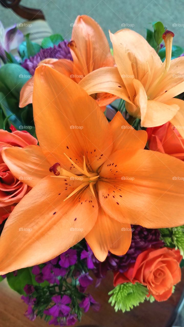 Closeup of orange lilies with orange roses