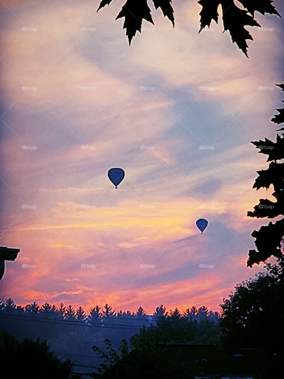 Beautiful sunset, distant hot-air balloons being set off from a local festival.