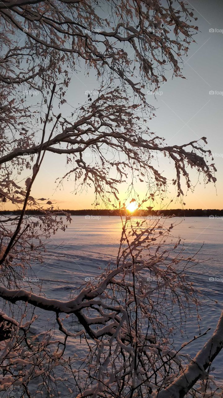A beautiful winter sunset over a frozen lake in Finland